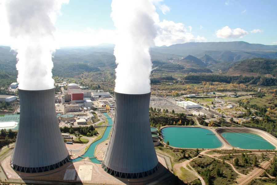 Vista aérea de la central nuclear de Cofrentes, con dos torres de refrigeración y el entorno montañoso.
