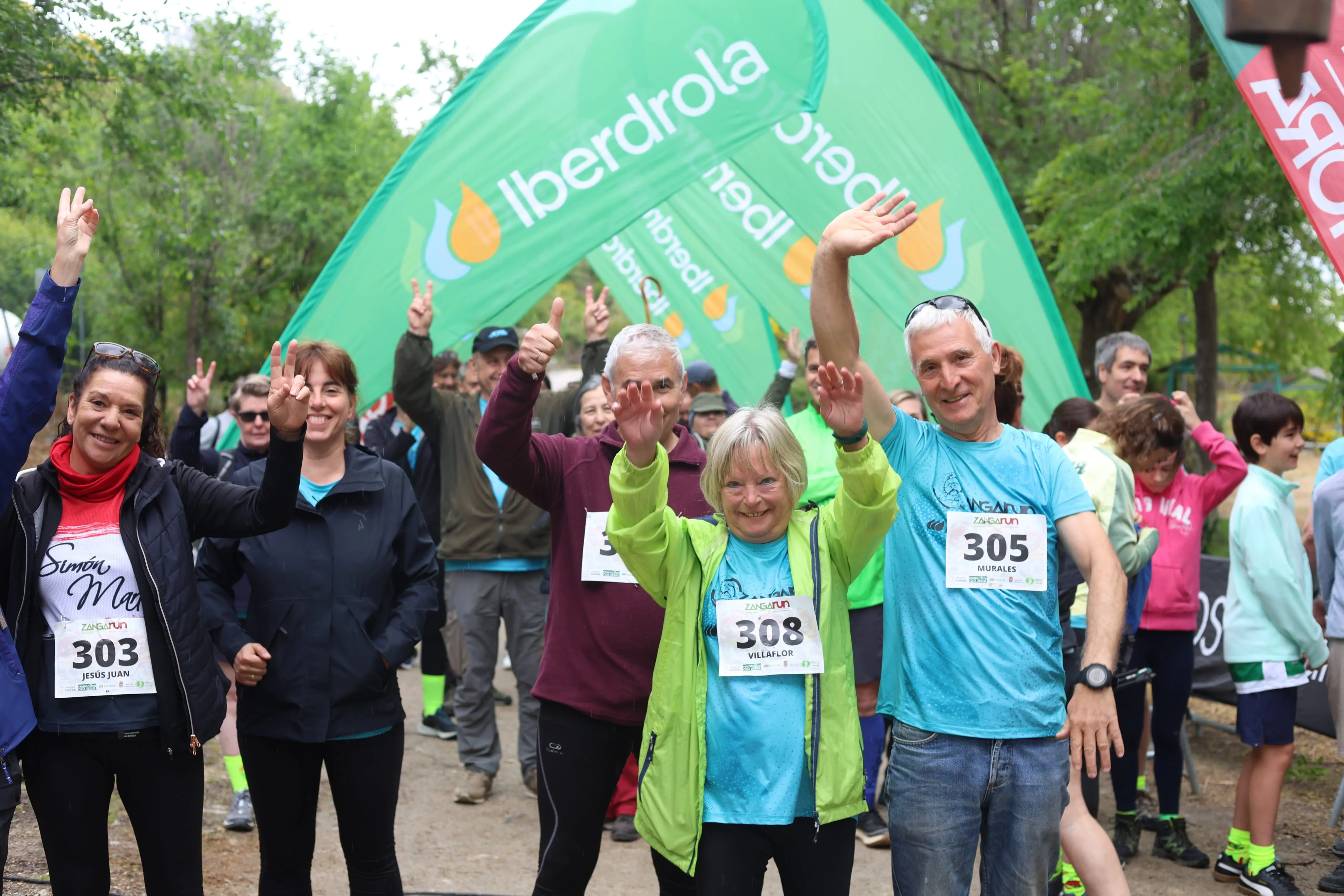Participantes de una carrera popular saludan bajo arco de Iberdrola en entorno natural
