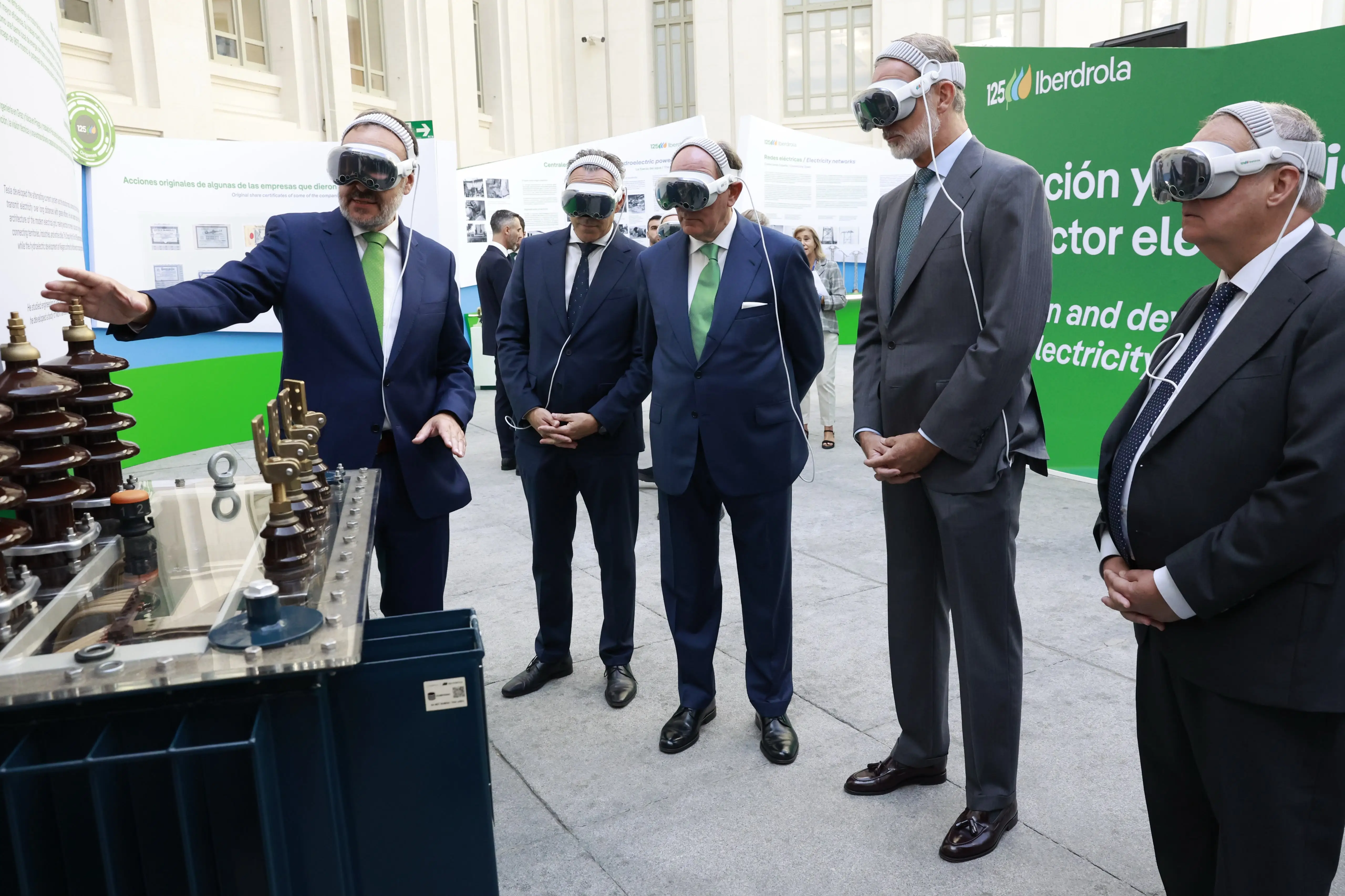El rey Felipe VI, Ignacio Galán y otros representantes observan con gafas de realidad virtual una instalación eléctrica de Iberdrola.