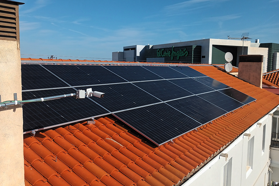 Instalación de paneles solares fotovoltaicos sobre el tejado de un edificio residencial, orientados para autoconsumo eléctrico.