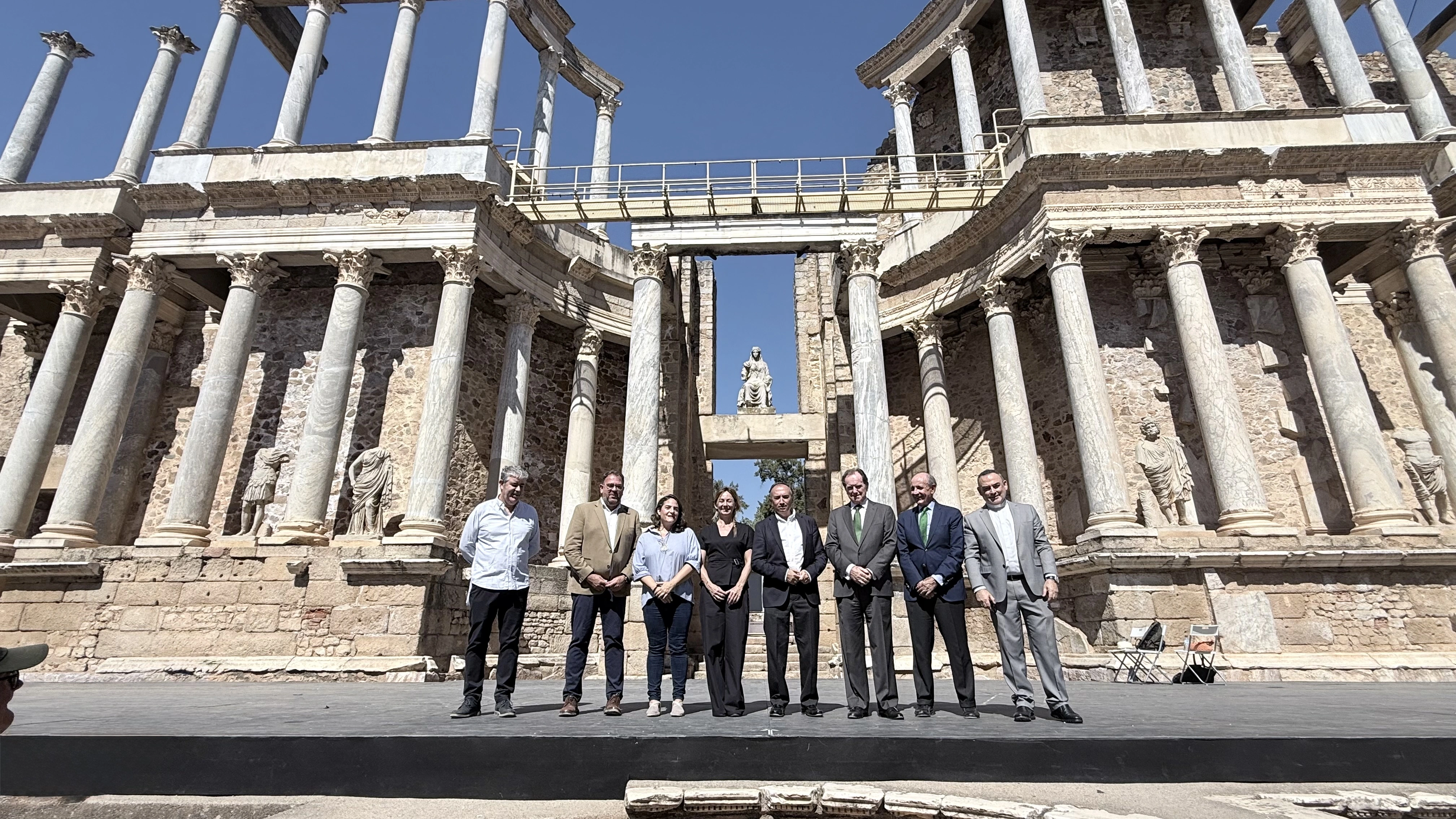Representantes institucionales posan ante el Teatro Romano de Mérida durante un acto celebrado en el recinto histórico.