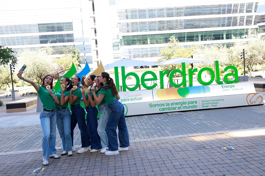 Gimnastas posando para un selfie frente a una instalación de Iberdrola durante una acción de voluntariado.
